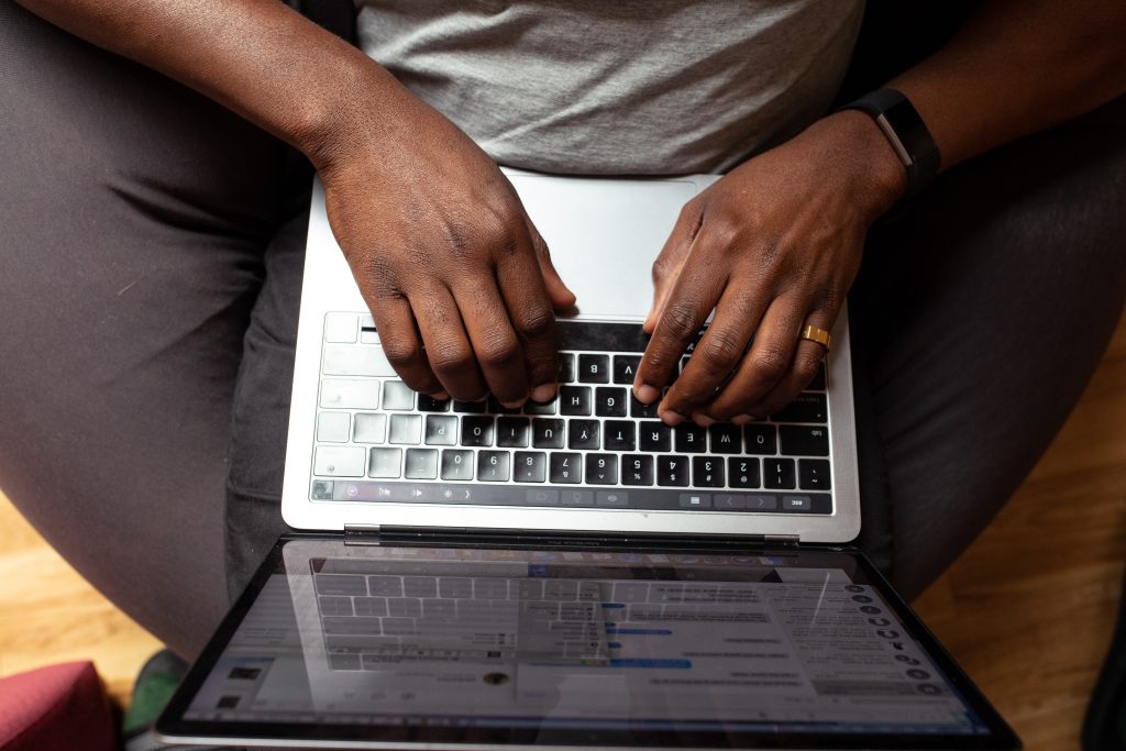 Black hands typing on Macbook